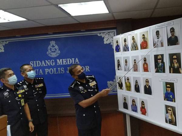 Ayob Khan ( kanan) menunjukkan warga asing yang terlibat dengan sindiket pelacuran yang berjaya ditumpaskan di sekitar Johor Bahru.