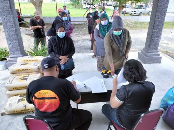 Orang ramai beratur dengan SOP ditetapkan ketika mengambil agihan sumbangan daripada Team Azyma Care Kota Bharu pada Ahad.