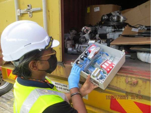 Pegawai JAS Pulau Pinang sedang memeriksa kontena dari Amerika Syarikat yang membawa bahan buangan e-sisa tanpa kebenaran di NBCT Butterworth pada Isnin.