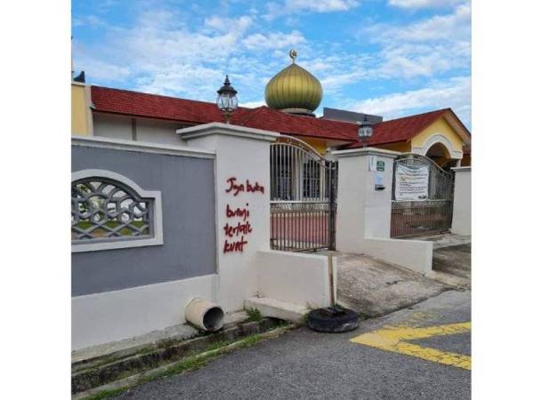 Polis menyiasat sebuah masjid di Taman SPPK, Ipoh yang diconteng dengan menggunakan cat merah. Foto: Ihsan pembaca