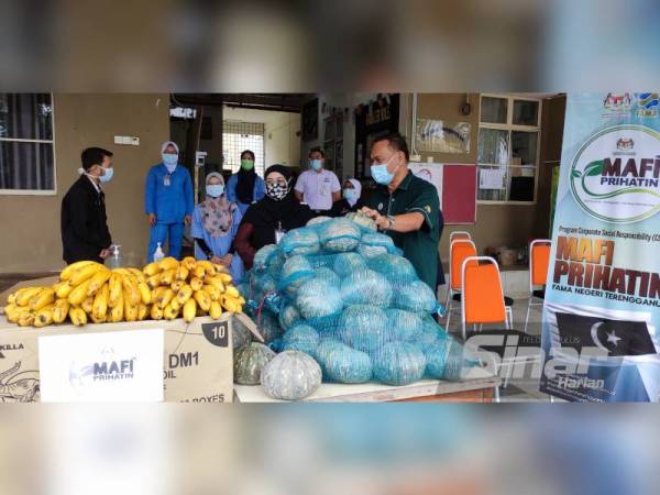 Che Ghani (kanan) berkata sesuatu kepada Pengarah Operasi PKRC UiTM Chendering, Dr Sharifah Azizaj Syed Mohammad selepas menyampaikan sumbangan melalui Program CSR MAFI Prihatin pada Rabu.