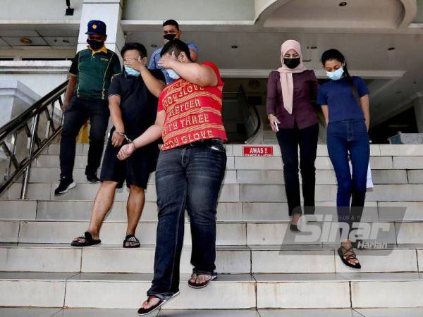 Tertuduh diiring polis di Kompleks Mahkamah Seremban pada Jumaat.