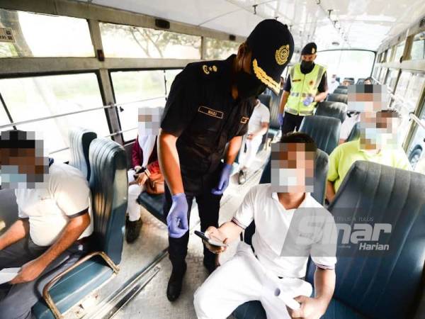 Nazli ketika membuat pemeriksaan ke atas sebuah bas yang membawa pekerja kilang di SJR Persiaran Budiman, Shah Alam pada Jumaat. - Foto Sinar Harian ROSLI TALIB