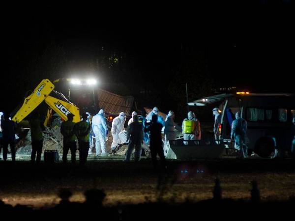 Petugas kesihatan yang lengkap berpakaian PPE ketika menguruskan pengkebumian jenazah pesakit Covid-19 dari Hospital Tengku Ampuan Rahimah Klang di Tanah Perkuburan Islam Seksyen 21 Shah Alam pada Jumaat. - Foto Bernama