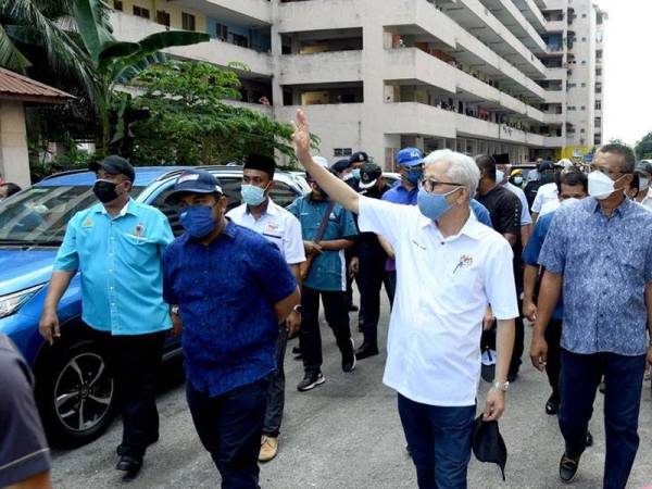 Ismail Sabri (dua dari kanan) melambai kepada penduduk ketika melawat Flat Seri Perantau, Pelabuhan Klang pada Sabtu.