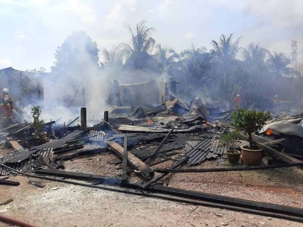 Anggota bomba bertungkus-lumus memadam kebakaran yang melibatkan kediaman dan kenderaan mangsa di Kampung Parit Pulai dekat Yong Peng, Batu Pahat petang Sabtu.