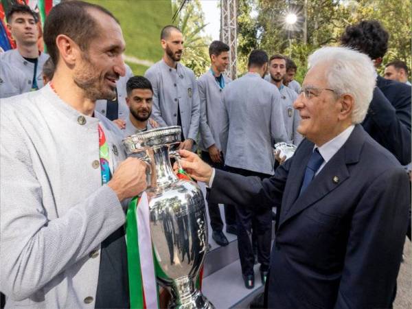 Mattarella (kanan) mengucapkan tahniah kepada Chiellini sambil memegang trofi Kejuaraan Euro 2020 pada 12 Julai lalu. - Foto AFP