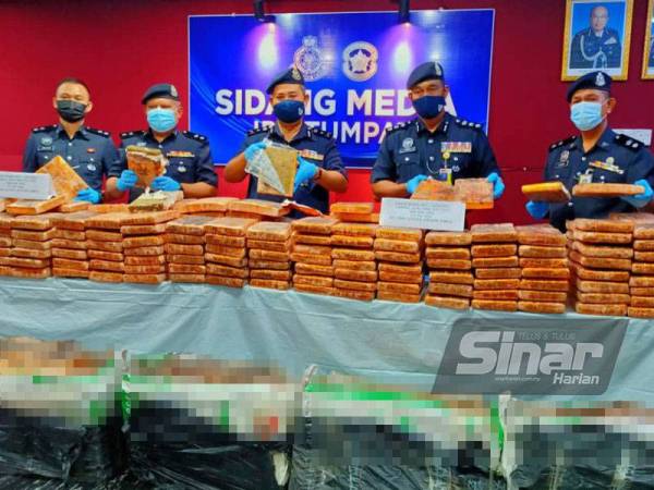 Abdullah (tengah) bersama pegawainya menunjukkan ketulan ganja mampat seberat 494 kilogram (kg) bernilai RM1.2 juta selepas sebuah kenderaan utiliti sukan (SUV) Honda CRV yang membawa bahan larangan itu terjunam ke dalam tali air di Kampung Lambor, Wakaf Bharu, di sini pada Jumaat.