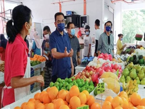 Azman (dua dari kiri) menerangkan sesuatu kepada peniaga ketika Ops Samar di Pasar Awam Taman Seri Gombak pada Ahad.