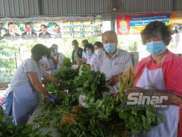 Sukarelawan menyiapkan bekalan sayur sebelum diedarkan kepada 2,000 keluarga di Tasek Gelugor dan Kepala Batas.