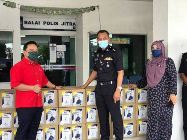 Wan Saiful (kiri) menyerahkan sebanyak 50 kotak bakul makanan kepada IPD Kubang Pasu di Balai Polis Jitra, Kedah.