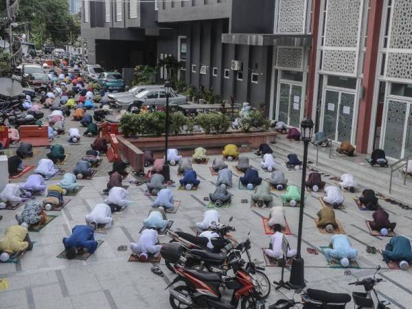 Sebahagian warga kota hadir menunaikan solat sunat Aidiladha dengan penjarakan fizikal dan memakai pelitup muka di sekitar pekarangan di Masjid Jamek Kampung Baru hari ini. - Foto Bernama