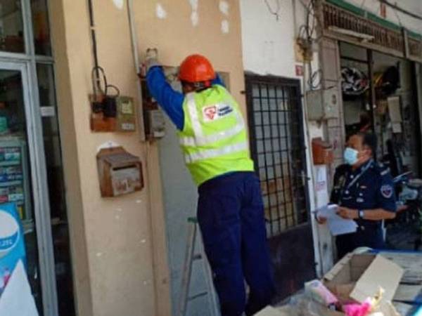 Kakitangan TNB melakukan pemotongan elektrik di premis yang dikenalpasti menjalankan aktiviti perjudian di daerah Kerian. Foto: Ihsan PDRM