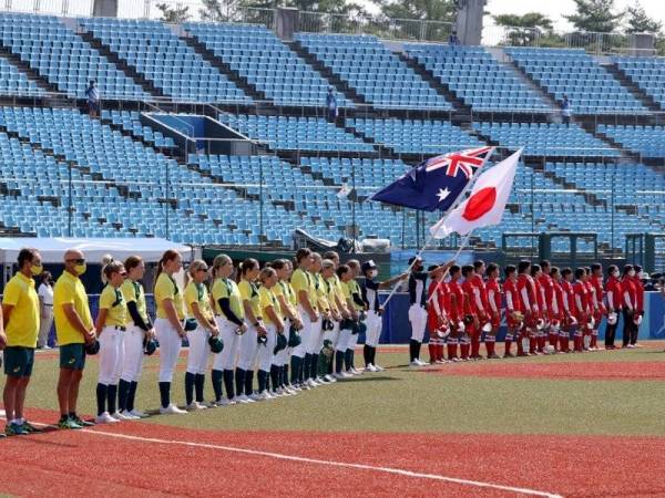 Pemain Jepun dan Australia sebelum acara sofbal wanita di Stadium Fukushima Azuma, wilayah yang teruk dilanda malapetaka nuklear selepas gempa bumi pada 2011. - Foto AFP