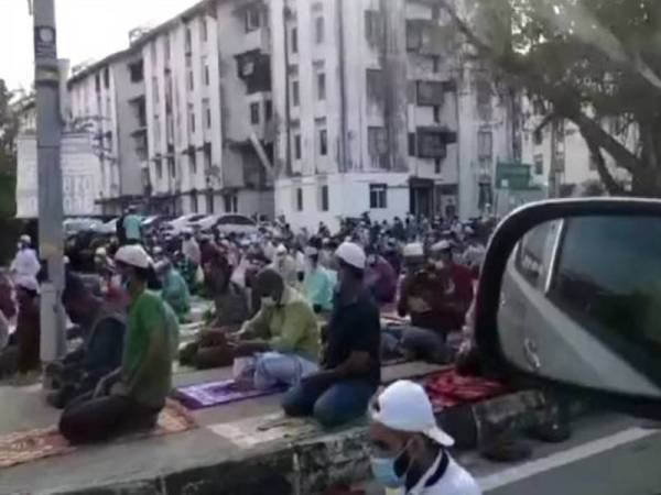 Tangkap layar video tular di Facebook pada Selasa menunjukkan warga asing menunaikan solat Aidiladha di kawasan lapang berdekatan pangsapuri Taman Pelangi, Juru.