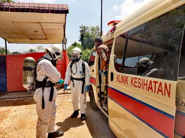 Pasukan HAZMAT bersedia membuat pemeriksaan dalam ambulans.