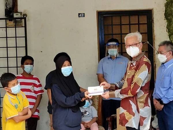 Ismail Sabri (dua dari kanan) menyerah bantuan kepada Nazurah sambil disaksikan oleh Dr Adham (kanan) dan Noraini (kiri) di Bukit Beruntung, Rawang pada Khamis.