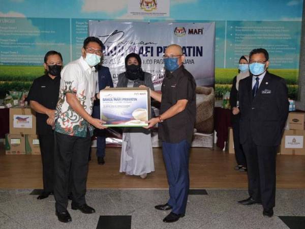 Ronald (kanan) ketika simbolik penyerahan daripada sebahagian penyumbang MAFI Prihatin. -Foto ihsan MAFI