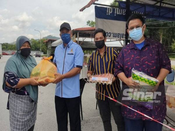 Dari kanan: Ahmad Soffian, Pengarah Urusan Qnin Inspired, Muhammad ‘Abduh dan Zakaria menyerahkan bakul makanan kepada penerima di Taman Sri Haneco, di sini pada Sabtu.