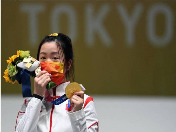 Yang Qian meraikan kejayaan merangkul pingat emas dalam acara 10 meter air rifle di Lapangan Menembak Asaka, Tokyo pada Ahad. - Foto AFP