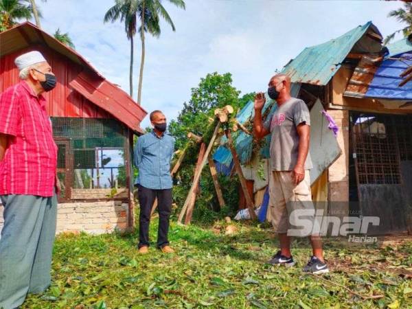 Wan Mohamed Khozani (kanan) menceritakan detik kejadian kepada Wan Hassan (dua dari kiri) yang hadir ke rumahnya di Kampung Sungai Petai di Pasir Puteh pada Sabtu.