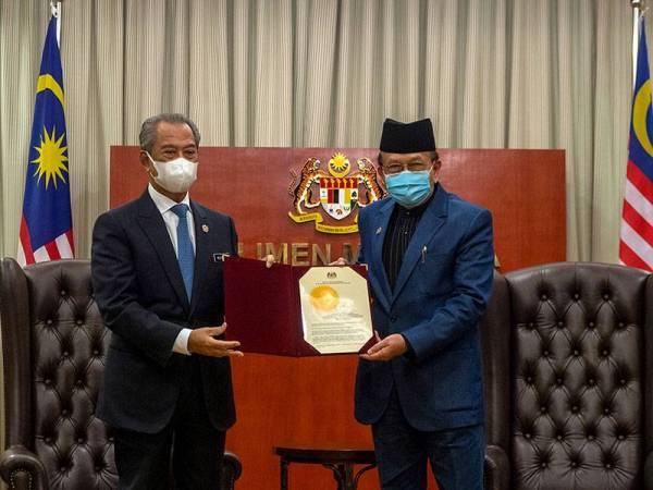 Perdana Menteri, Tan Sri Muhyiddin Yassin (kiri) menyampaikan watikah pelantikan Ahli Jawatankuasa Khas mengenai Rasuah kepada Yang Dipertua Dewan Negara Senator Tan Sri Dr Rais Yatim di Parlimen pada Isnin. - Foto Bernama