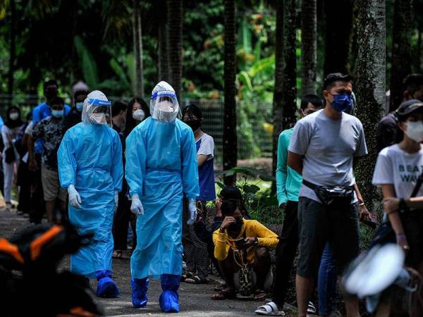 Petugas barisan hadapan lengkap berpakaian PPE ketika berada di pekarangan Pusat Penilaian Covid-19 (CAC) di Kompleks Sukan Bandar Tun Razak pada Isnin. Foto Bernama