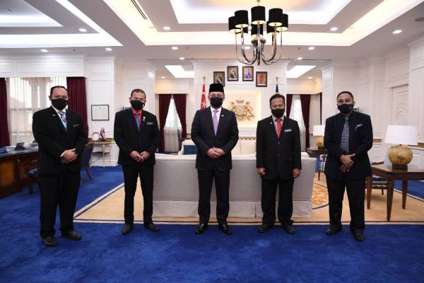 Che Zakaria (dua dari kiri) dan Hasni (tengah) selepas penyerahan sumbangan pihak Kejora untuk Tabung Bencana Negeri Johor di Pejabat Menteri Besar Johor, Kota Iskandar, Iskadar Puteri pada Rabu.