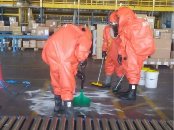 Pasukan Hazmat membersihkan bahan kimia yang tertumpah di atas lantai gudang di LTAPP, Bayan Lepas pada Rabu.