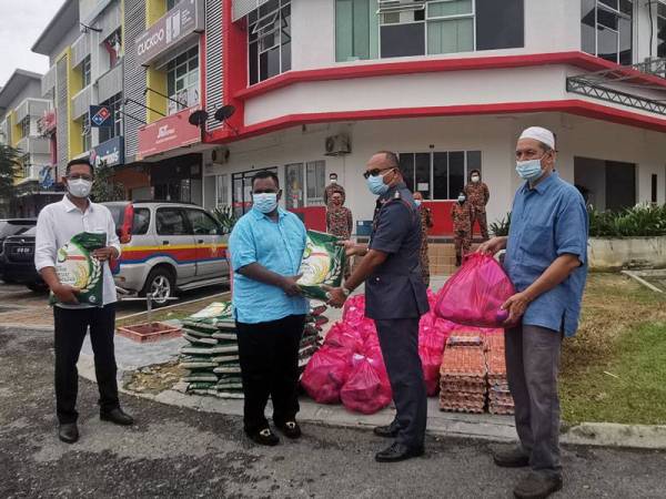 Saravana Kumar (dua dari kiri) menyampaikan bantuan barangan keperluan kepada Ketua Balai Bomba dan Penyelamat Seremban, Mohammad Idris. Turut kelihatan Mustafa (kiri) dan Abu Ubaidah (kanan).