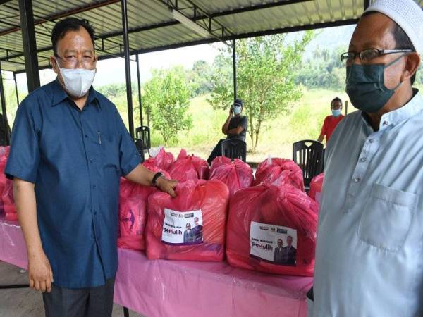 Eddin Syazlee (kiri) melihat sumbangan berupa bakul makanan sebelum menyampaikannya kepada penerima pada program Agihan Bakul Makanan Pemulih di Masjid Kariah Sungai Jelutong, hari ini. - Foto Bernama