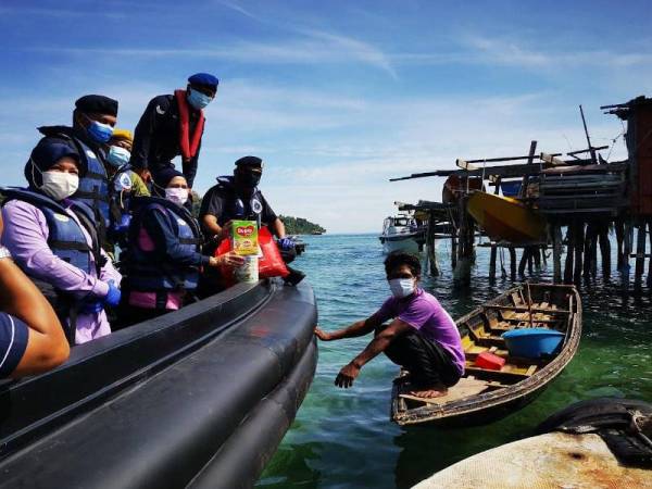 Mohd Zaidi menyampaikan susu dan makanan bayi kepada Jammara yang terjejas berikutan pelaksanaan PKPD di Pulau Gaya.