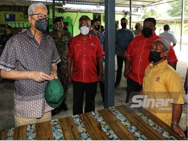 Ismail Sabri (kiri) sedang mendengar aduan penduduk ketika lawatan kerja di Parlimen Bera pada Ahad.