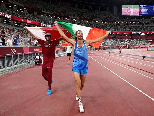 Barshim (kiri) bersama Tamberi meraikan kejayaan memenangi emas dalam acara lompat tinggi lelaki di Stadium Olimpik, Tokyo pada Ahad. - Foto AFP