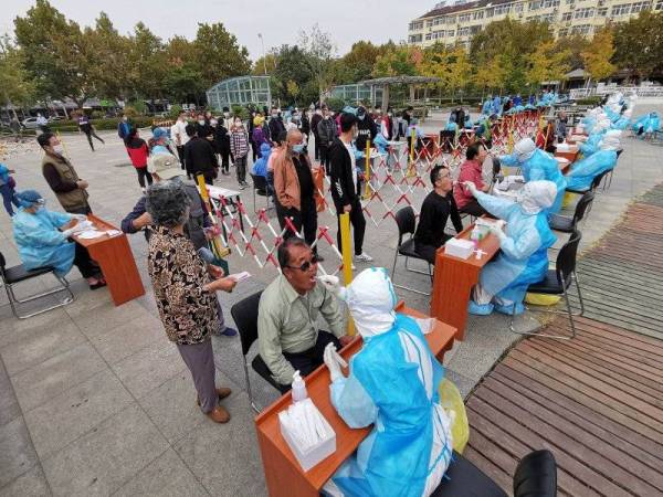 China melakukan ujian saringan ke atas jutaan penduduk sejak akhir minggu lalu. - Foto: AFP