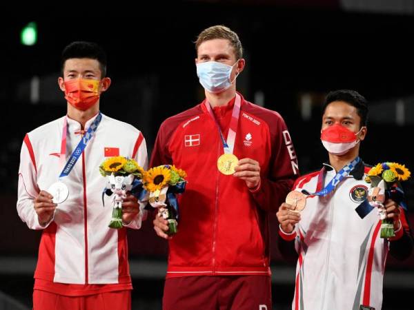 Axelsen (tengah), Chen Long (kiri) bersama pingat masing-masing selepas perlawanan akhir acara badminton perseorangan lelaki Tokyo 2020. Turut kelihatan pemenang pingat gangsa, Anthony Sinisuka Ginting (kanan) dari Indonesia. - Foto AFP