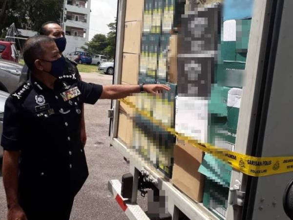 Ayob Khan menunjukkan sebahagian daripada arak tiruan yang dirampas melibatkan nilai RM2.1 juta, selepas sidang akhbar di IPK Johor, Johor Bahru, pada Selasa.