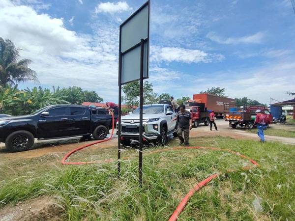 Pasukan sedang mengisi air ke dalam tangki sebelum dibawa ke rumah penduduk yang terjejas.