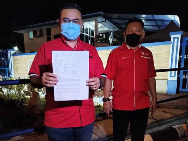 Khairul Anuar menunjukkan laporan polis yang dibuatnya terhadap Ahmad Zahid di Balai Polis Kulim Hi-Tech pada petang Rabu.