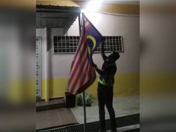 Anggota polis memeriksa Jalur Gemilang di lokasi kejadian yang didapati tiangnya telah patah.