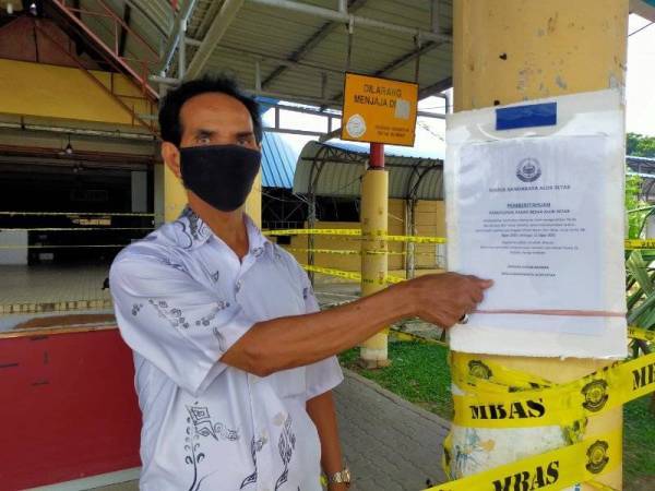 Mohd Fauzi menunjukkan notis penutupan operasi yang ditampal di laluan masuk Pasar Besar Alor Setar di sini.