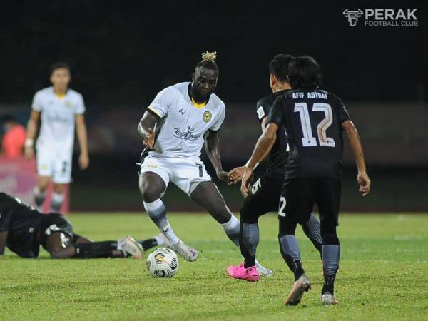 Penyerang Perak, Nana Poku cuba melepasi kawalan pertahanan UiTM FC dalam aksi di Stadium UiTM pada Sabtu. FOTO: PERAK FC