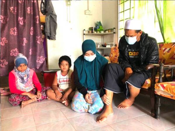 Noraini (dua dari kanan) melihat kaki kanan suaminya, Mohd Faizal (kanan) yang menderita penyakit buah pinggang kronik tahap lima. - FOTO SINAR HARIAN