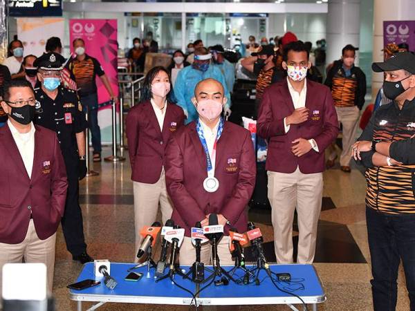 Azizulhasni bersama pingat perak yang dimenanginya sewaktu tiba di KLIA selepas beraksi pada Sukan Olimpik Tokyo 2020 pada Isnin. Turut hadir Menteri Belia dan Sukan Datuk Seri Reezal Merican Naina Merican  (kanan). - Foto Bernama