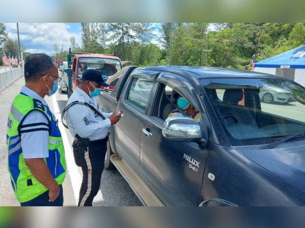 Barudin (kiri) memantau penugasan anggota di SJR Jalan Ipoh - Lumut berhampiran Universiti Teknologi Petronas (UTP).