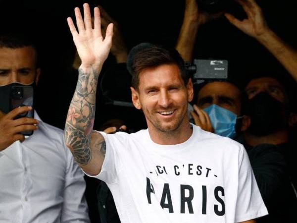 Messi melambaikan tangan kepada penyokongnya di lapangan terbang Le Bourget. - Foto AFP