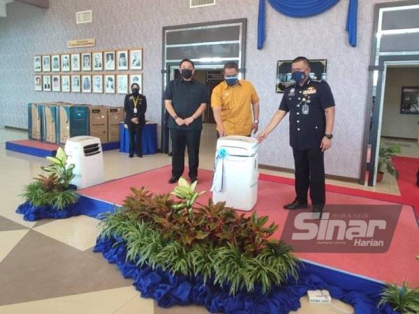 Muhammad Sanusi (tengah) membuat penyerahan penyaman udara mudah alih kepada Kamarul Zaman (kanan) di Ibu Pejabat Polis Kontinjen (IPK) Kedah pada Rabu.