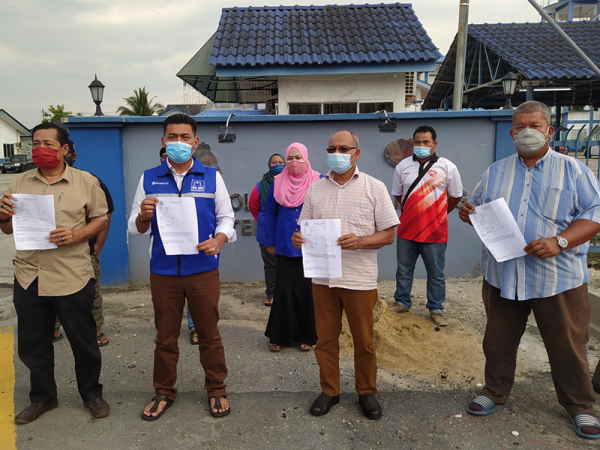 Mohd Rizan (dua dari kiri) menunjukkan laporan polis yang dibuat di hadapan Balai Polis Hutan Melintang di sini pada Rabu.