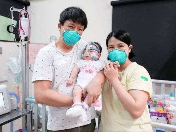 Kwek Yu Xuan (tengah) akhirnya dibenarkan keluar dari Hospital Universiti Nasional Singapura baru-baru ini setelah dilahirkan pada 9 Jun tahun lalu. - Foto NUS