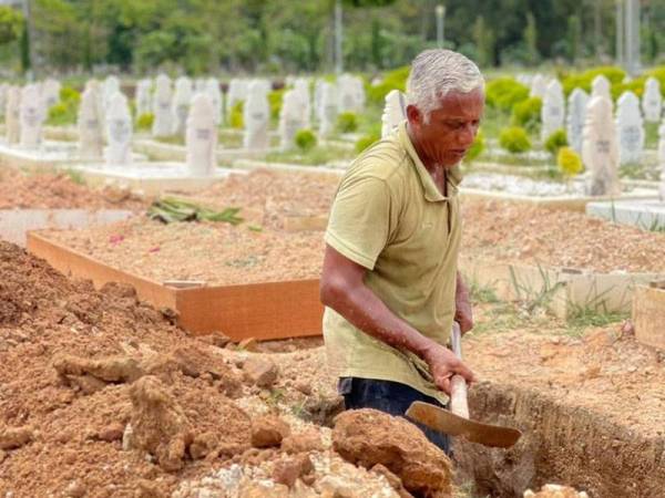 Roslee melakukan tugas menggali kubur di Tanah Perkuburan Islam Raudhatul Sakinah Taman Selasih, Kuala Lumpur.